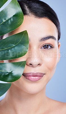 Buy stock photo Plant, portrait or woman with skincare for beauty on blue background with herbs, shine or glow. Monstera leaf, confident model or face of girl in studio with cosmetics, hydration or makeup results