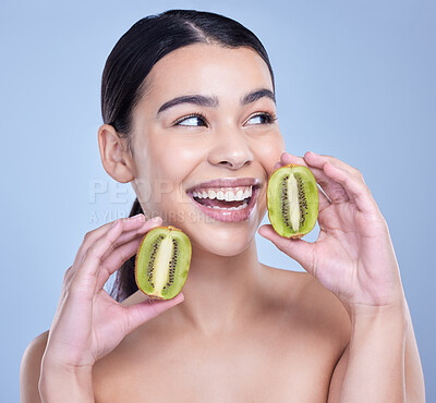 Buy stock photo Studio, thinking and woman with kiwi for skincare, vitamin c and minerals for nutrient for healthy living. Female person, face and fruit by blue background for wellness, organic and beauty treatment