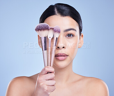 Buy stock photo Studio, portrait and female model with brush for makeup, foundation and cosmetics for application. Woman face, results and spa for transformation, beauty and creativity with tools by blue background