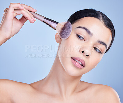 Buy stock photo Woman, studio and confident with brush for makeup routine with cosmetics for beauty on blue background. Female person, isolated and self care with skin glow or smooth for glamour and apply foundation