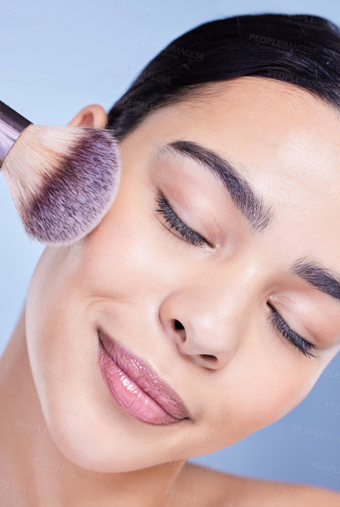 Buy stock photo Woman, studio and eyes closed with brush for makeup routine with cosmetics and beauty on blue background. Female person, smile and self care with skin glow or smooth for glamour and apply foundation