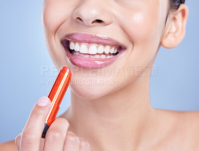 Buy stock photo Woman, smile and lipstick in studio for makeup, cosmetics and beauty on blue background with glow. Female person, mouth and lip gloss in closeup for aesthetic, facial and transformation with shine 