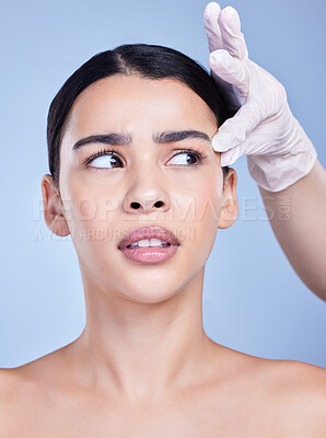 Buy stock photo Woman, face and plastic surgery with gloves for facial transformation on blue studio background. Young female person with hands of medical surgeon for beauty makeover, change or cosmetic implant