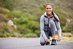 Active and fit woman tying the laces of her sneakers for exercise outdoors. Athlete fixing her shoes to get ready for a run or jog in the morning. Preparing for a refreshing cardio workout outside