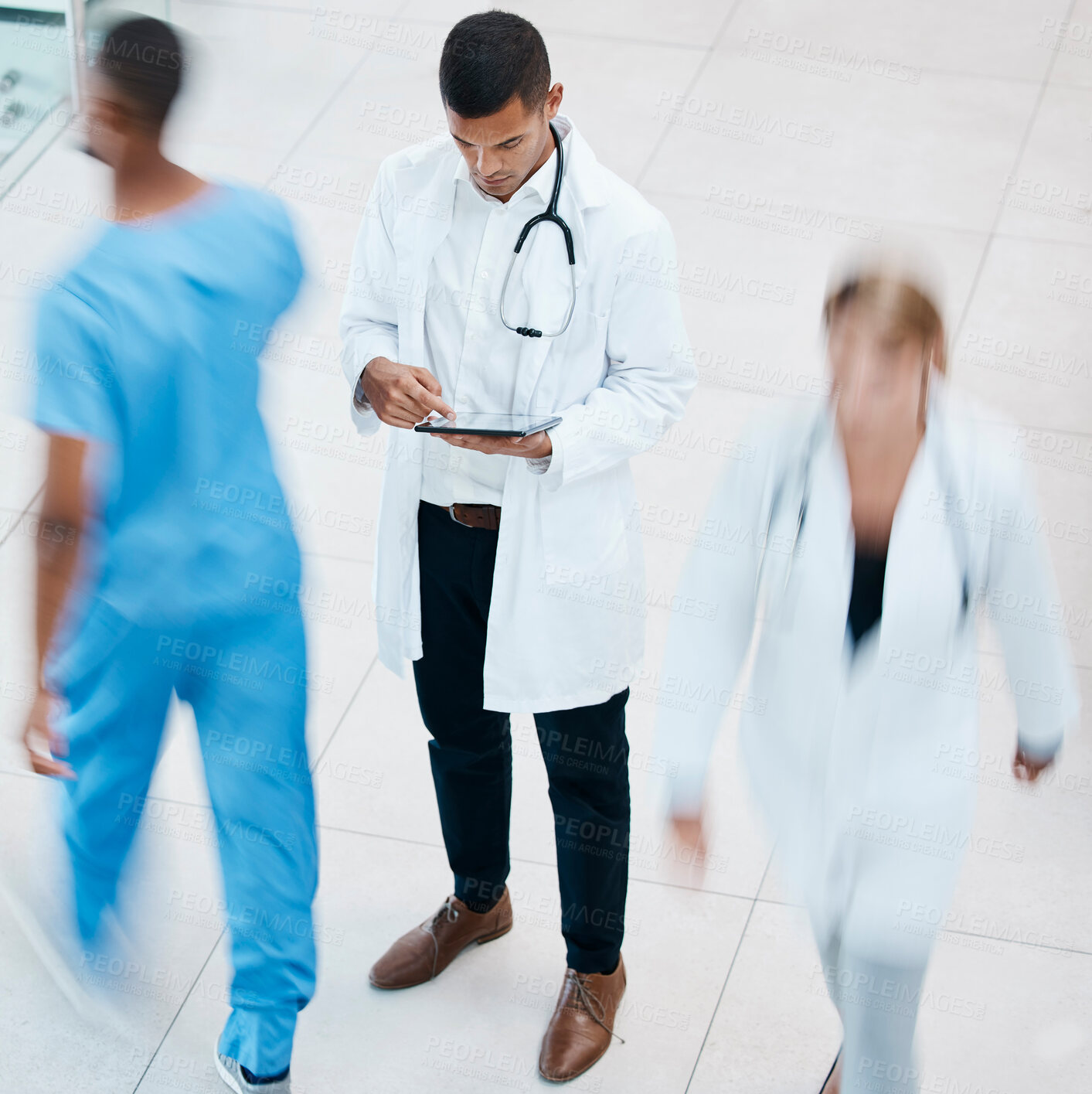 Buy stock photo Busy hospital with doctor browsing on tablet for test results, patient records and medical research from above. Healthcare professional and expert working on treatment plan in a bustling clinic