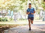 One active young indian man exercising outdoors. Handsome male athlete enjoying a jog or run for cardio training workout. Determined to build muscle and endurance for fitness and wellness goals