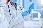 Shot of a female doctor preparing a dose of medication in a syringe while wearing a mask and labcoat inside of a hospital room. Ready to administer an injection of the corona virus vaccine to patients