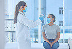 Patient having her temperature checked with a thermometer. Doctor in a clinic using a thermometer to monitor a patients temperature. Patient in a checkup for corona virus in a hospital