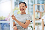 Young happy mixed race female patient smiling while removing a mask at a checkup standing at a hospital. Confident hispanic woman wearing a mask while at a hospital