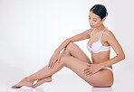 A beautiful young mixed race model posing seductively in underwear against a white studio copyspace background. Confident hispanic woman showing her curvy shape and smooth hairless legs