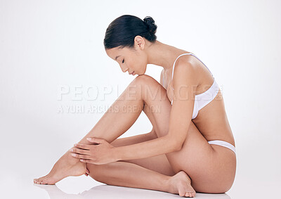 Buy stock photo Woman, hair removal and clean legs in studio for skincare, beauty and soft touch on white background. Female person, epilation and grooming results for maintenance, dermatology and cosmetics glow