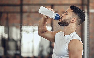 Buy stock photo Man, fitness and drinking with water bottle for hydration, thirst or natural sustainability after workout at gym. Active male person with mineral liquid or body fuel for break or recovery in exercise