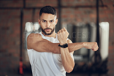 Buy stock photo Man, portrait and stretching arms in gym for warm up, daily workout routine and fitness for muscle development. Male person, serious and flexing for physical cardio, training or exercise for health.