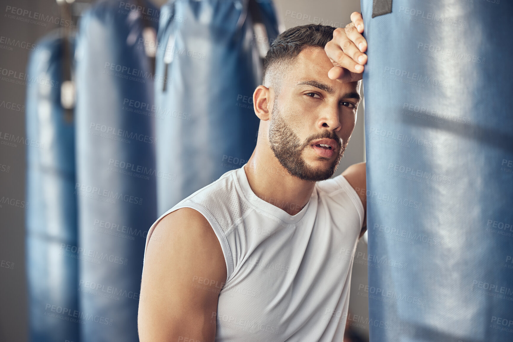 Buy stock photo Tired man, portrait and boxer with punching bag for self defense training, practice or martial arts at gym. Exhausted male person or fighter in fitness for break after intense exercise or boxing