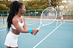 Young athlete waiting to serve during a tennis match. Focused african american tennis player during a match. Girl playing tennis with her friend. Sporty woman competing in a tennis match