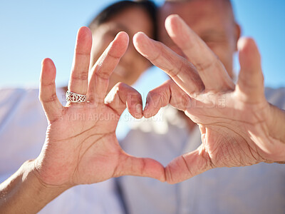 Buy stock photo Hands, closeup and couple with heart for love, care and connection together on holiday outdoor. Fingers, senior man and woman with romance sign, support or loyalty for relationship commitment emoji