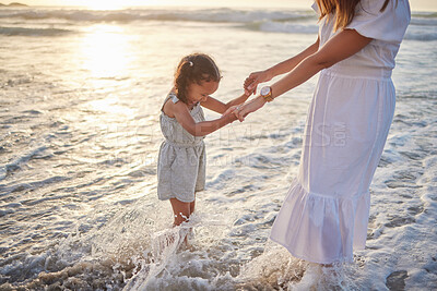 Buy stock photo Mom, girl and holding hands in water on beach for adventure, summer vacation and family time together. Waves, mother and daughter by sea for holiday with support, love and fun to explore nature.