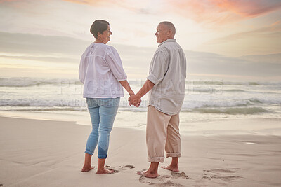 Buy stock photo Happy, mature couple and holding hands on beach with love, bonding and romance date on retirement travel. Smile, woman and man for walking of relationship, ocean sunset or loyalty together on holiday