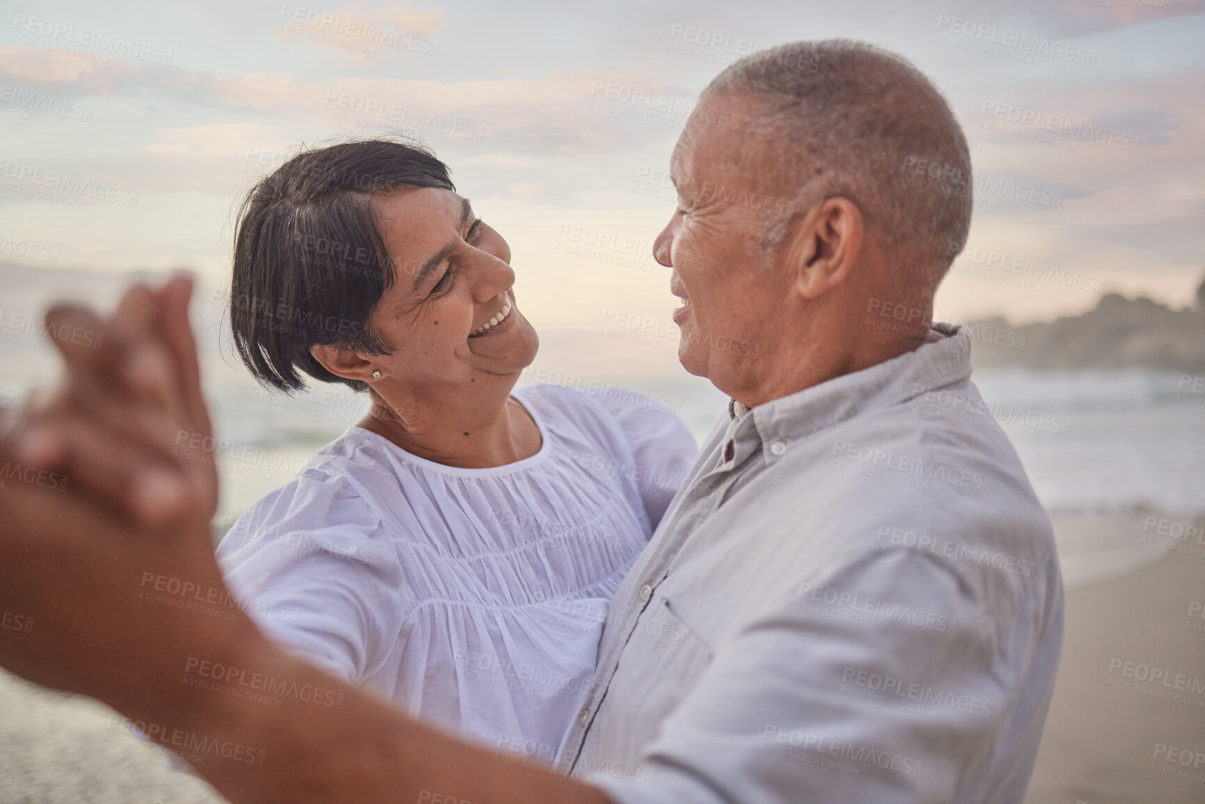 Buy stock photo Happy, mature couple and dancing on beach with love, bonding and romance date for retirement travel. Smile, woman and man with embrace fun of relationship, commitment and loyalty on ocean outdoor