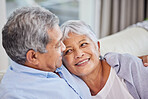 Closeup of an affectionate mixed race senior couple relaxing in their living room at home. Hispanic man and wife  bonding on the sofa in the living room being affectionate