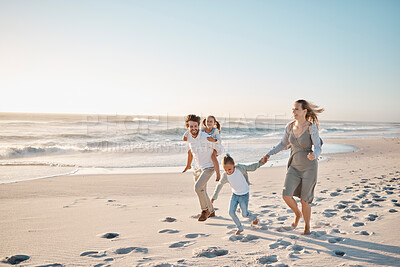 Buy stock photo Parents, kids and happy at beach, holding hands and running with piggy back, bonding and mockup space. People, children and laughing on vacation, adventure and playful in sunshine by ocean in Spain