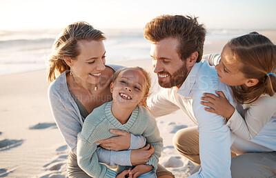 Buy stock photo Parents, children and hug at beach, holiday and smile with care, love or bonding on ground in summer. Father, mother and daughter kids for laughing, family or connection in sunshine by ocean in Spain