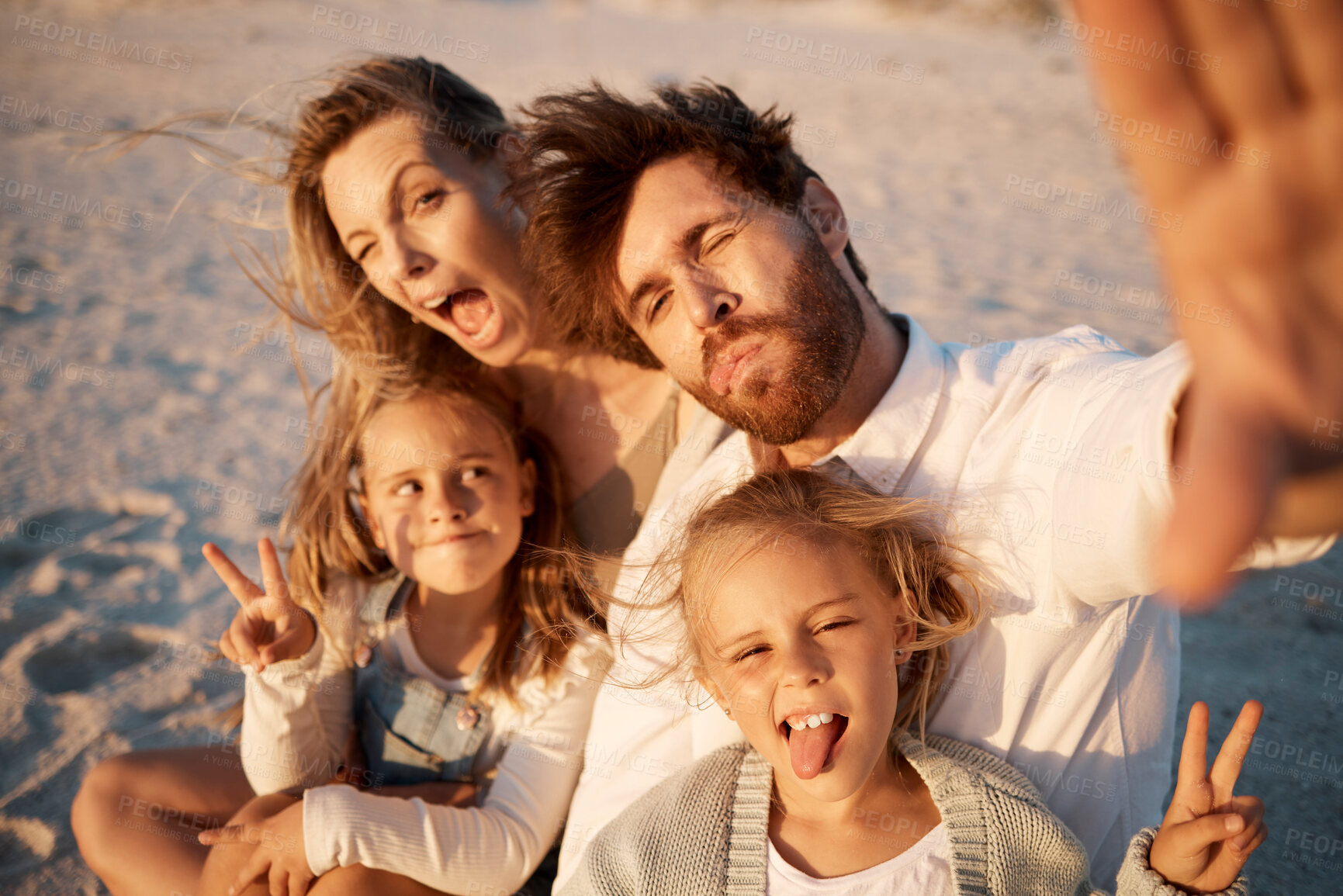 Buy stock photo Parents, kids and selfie at beach, funny face or smile with care, love or tongue out for memory in summer. Father, mother and daughter children with peace sign, family or portrait on holiday in Spain