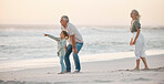 Grandparents bonding with their grandchild. Grandfather talking to his grandchild on the beach. Little girl on holiday with her grandparents. Mature couple on vacation with their grandchild.