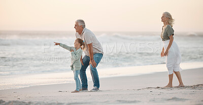 Buy stock photo Grandparents, girl and pointing at beach for travel, bonding and sunset while on vacation together. Family, generations and fun outdoor by sea for dusk, relationship and adventure on tropical holiday