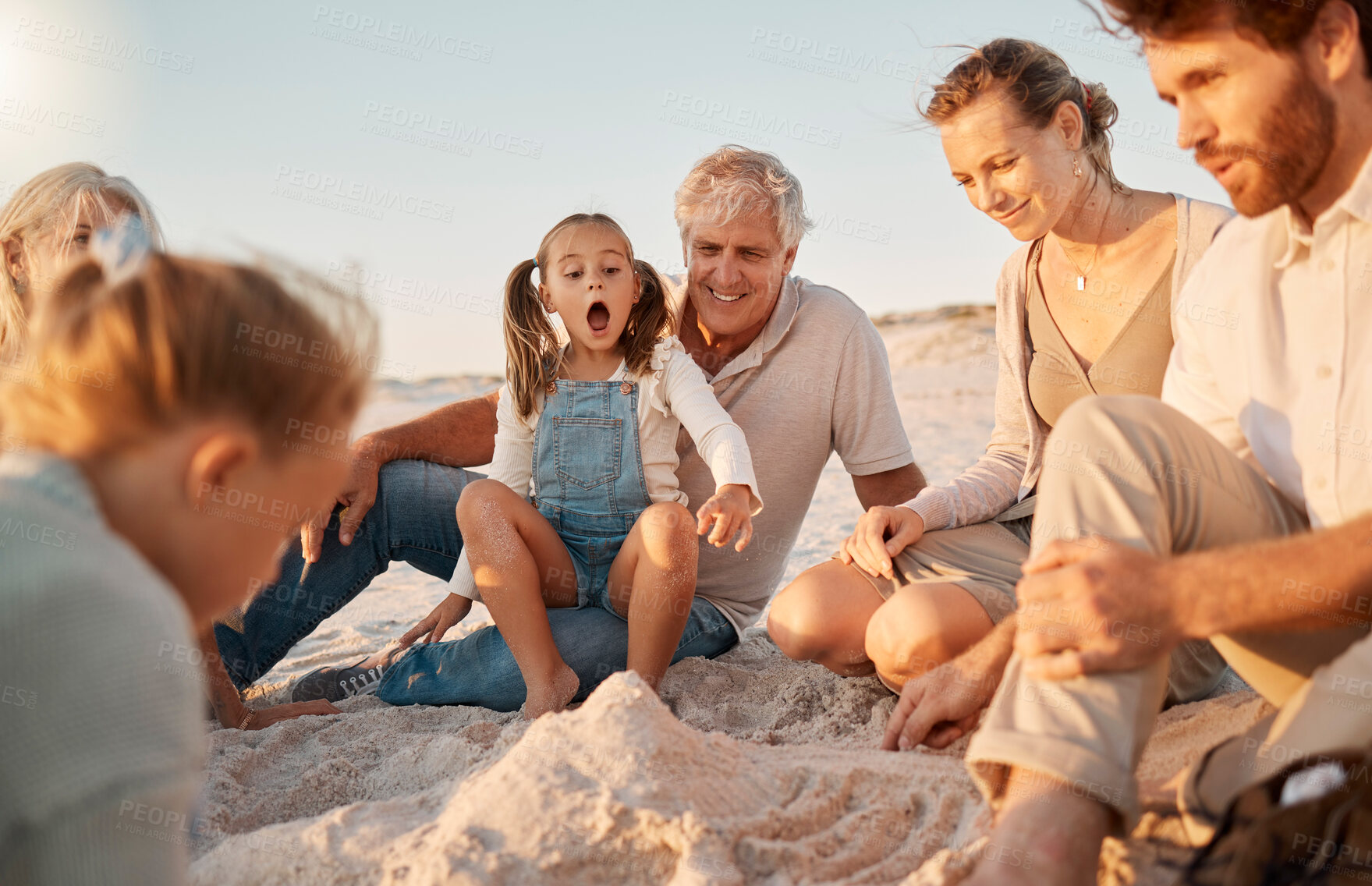 Buy stock photo Family, children and generations at beach for sand castle with bonding, excited and wow on vacation. Parents, grandfather and kids on ground with surprise, helping hand and happy for game in Spain