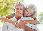 A happy mature caucasian couple embracing and showing love while relaxing together at home. Retired couple bonding while sitting together