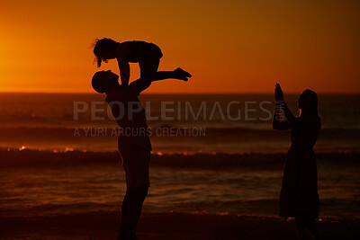 Buy stock photo Sunset, parents and kid with lifting at beach for bonding on break, relax and fun in Spain. People, family and playful on silhouette at ocean on holiday with happiness for child development or growth