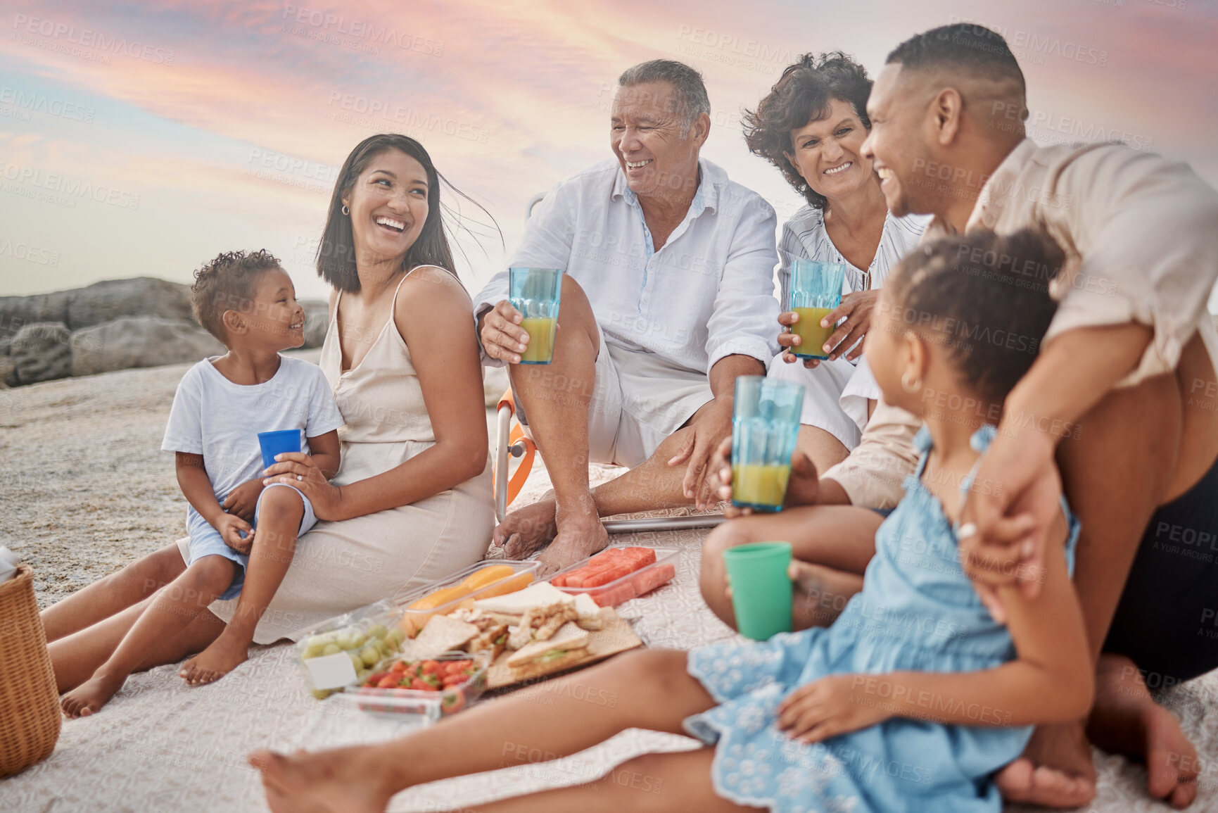 Buy stock photo Happy family, beach and drink juice at picnic for holiday, summer and travel. Lunch, food and people by sea with parents, generations and kids with grandparents at thanksgiving celebration to relax