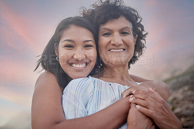 Buy stock photo Beach, hug and portrait of mother with daughter outdoor at sunset for holiday, travel or vacation together. Face, love or smile with senior parent and woman embracing on coast for bonding or getaway