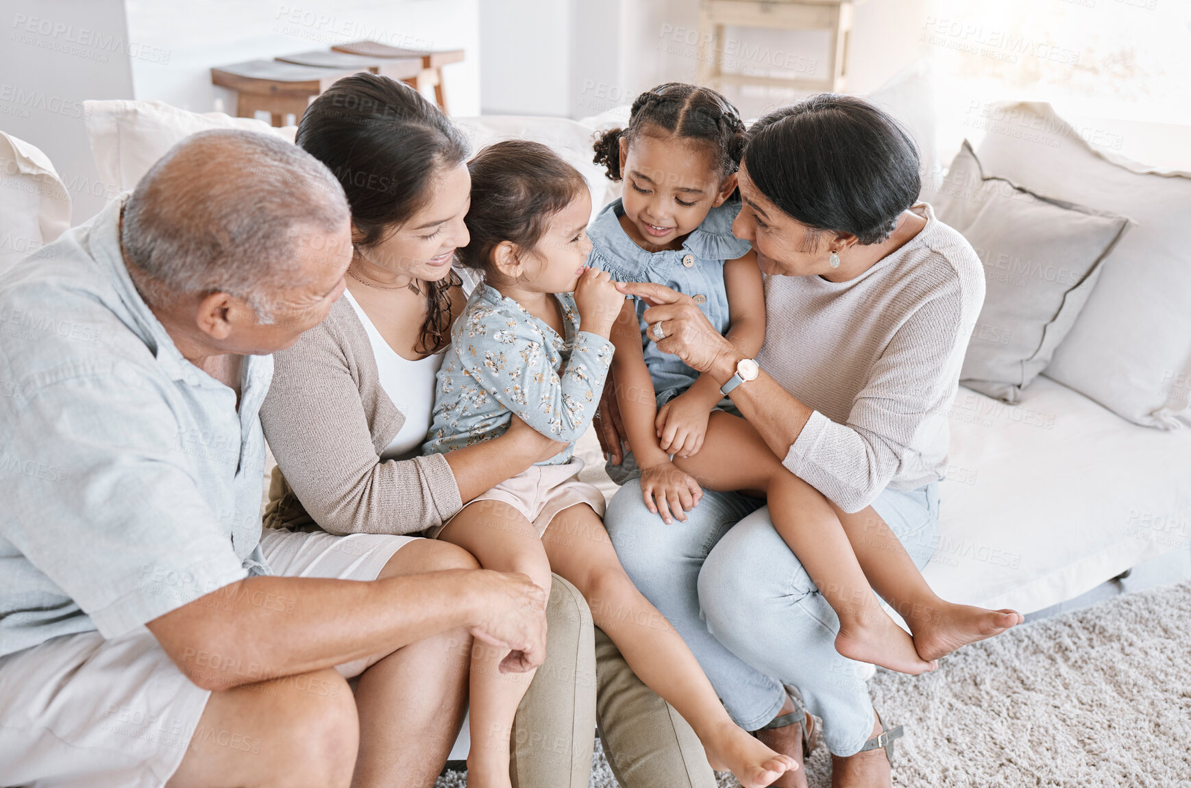 Buy stock photo Mother, home and grandparents with kids on sofa, bonding together and happiness in lounge. Apartment, generations and big family on couch, smile and love with break, playful and laughing with care