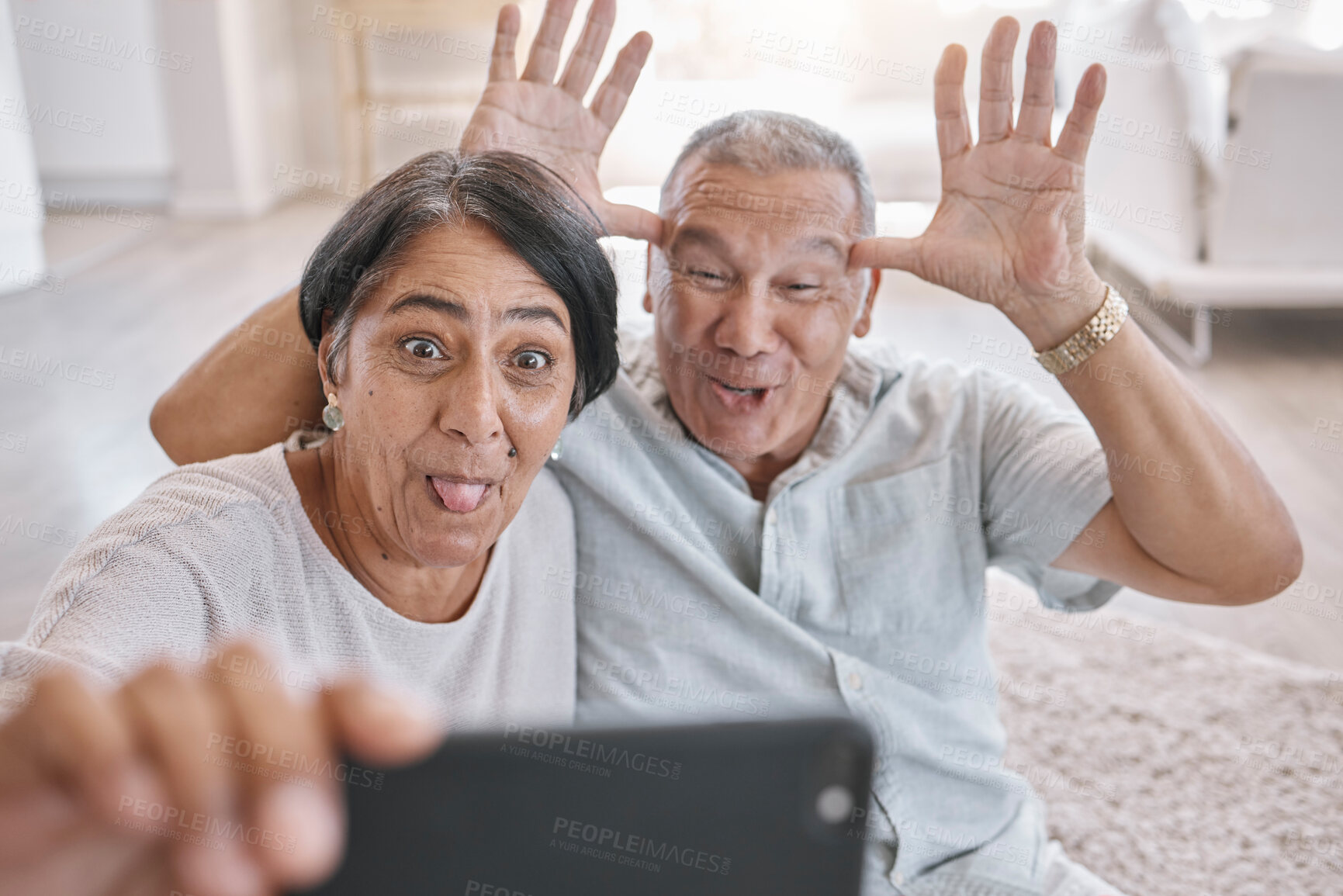 Buy stock photo Senior couple, selfie and funny in home for love, fun and relax in retirement. Crazy, elderly people and comic face in living room for photography, teasing and tech for live stream or video call