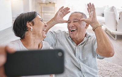 Buy stock photo Elderly couple, selfie and happy in home for love, funny and silly face in retirement. Laugh, senior people and joke in living room for photography, bonding and tech for live stream or video call