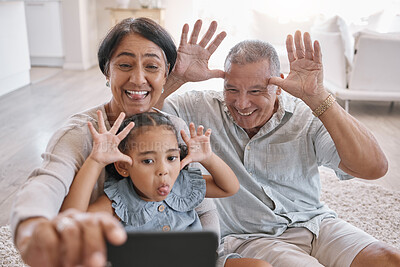 Buy stock photo Grandparents, kid and crazy in home for selfie, funny and silly face in retirement. Tongues out, senior people and girl in living room for photography, bonding and tech for live stream or video call