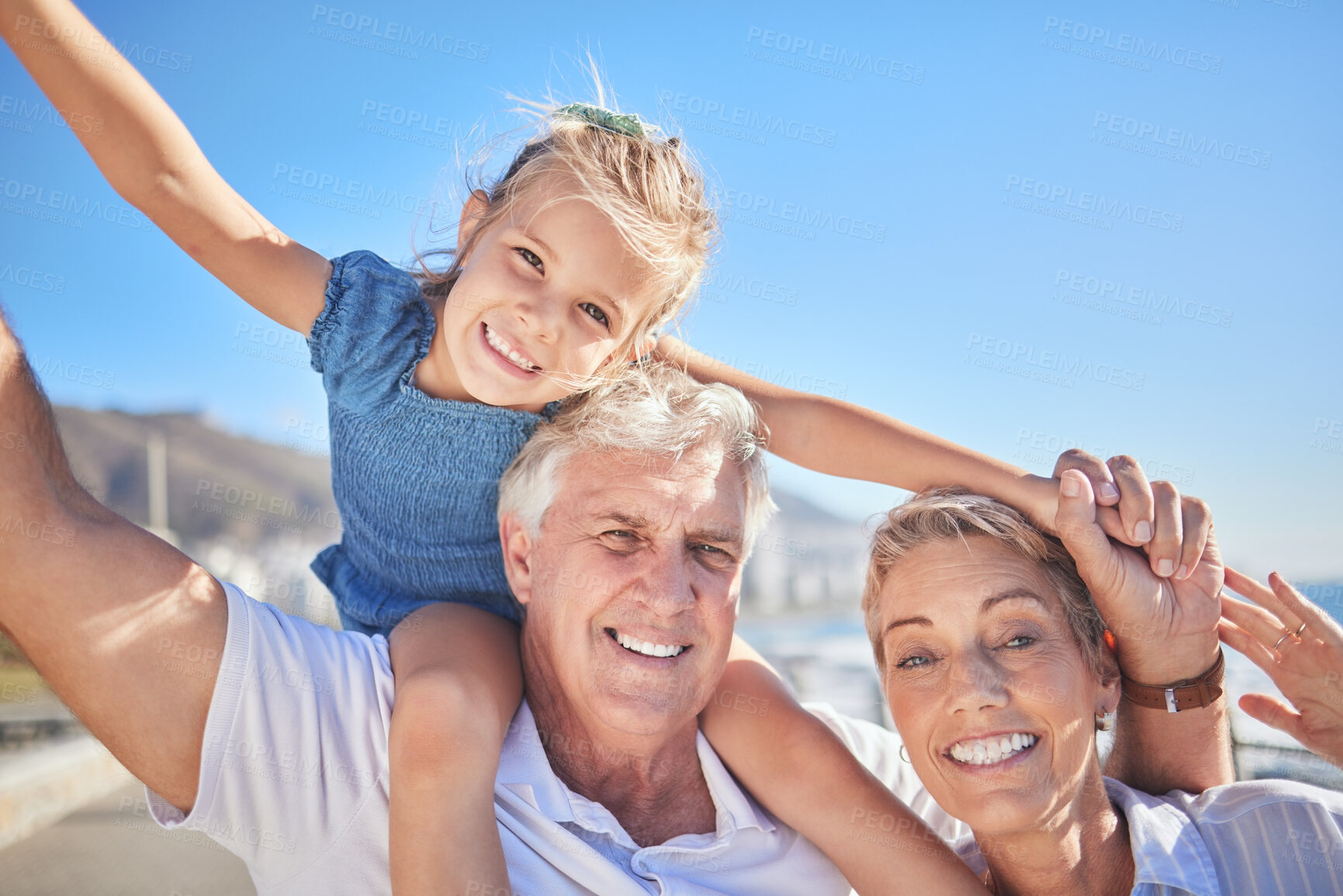 Buy stock photo Portrait, girl and grandparents for summer travel, family holiday and vacation adventure. Happy child, blue sky and shoulder ride with smile, joy and tourism for childhood bonding and outdoors fun