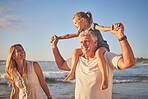 Closeup of a little caucasian girl being carried by her grandpa while her mother walks on the beach during sunset.  Family fun in the summer sun