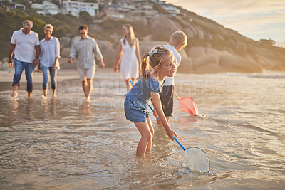 Buy stock photo Family, beach and fish net fun with parents and kids together with grandparents outdoor. Sunset, travel and love of generations with smile, happy youth and support on holiday by the sea in Florida