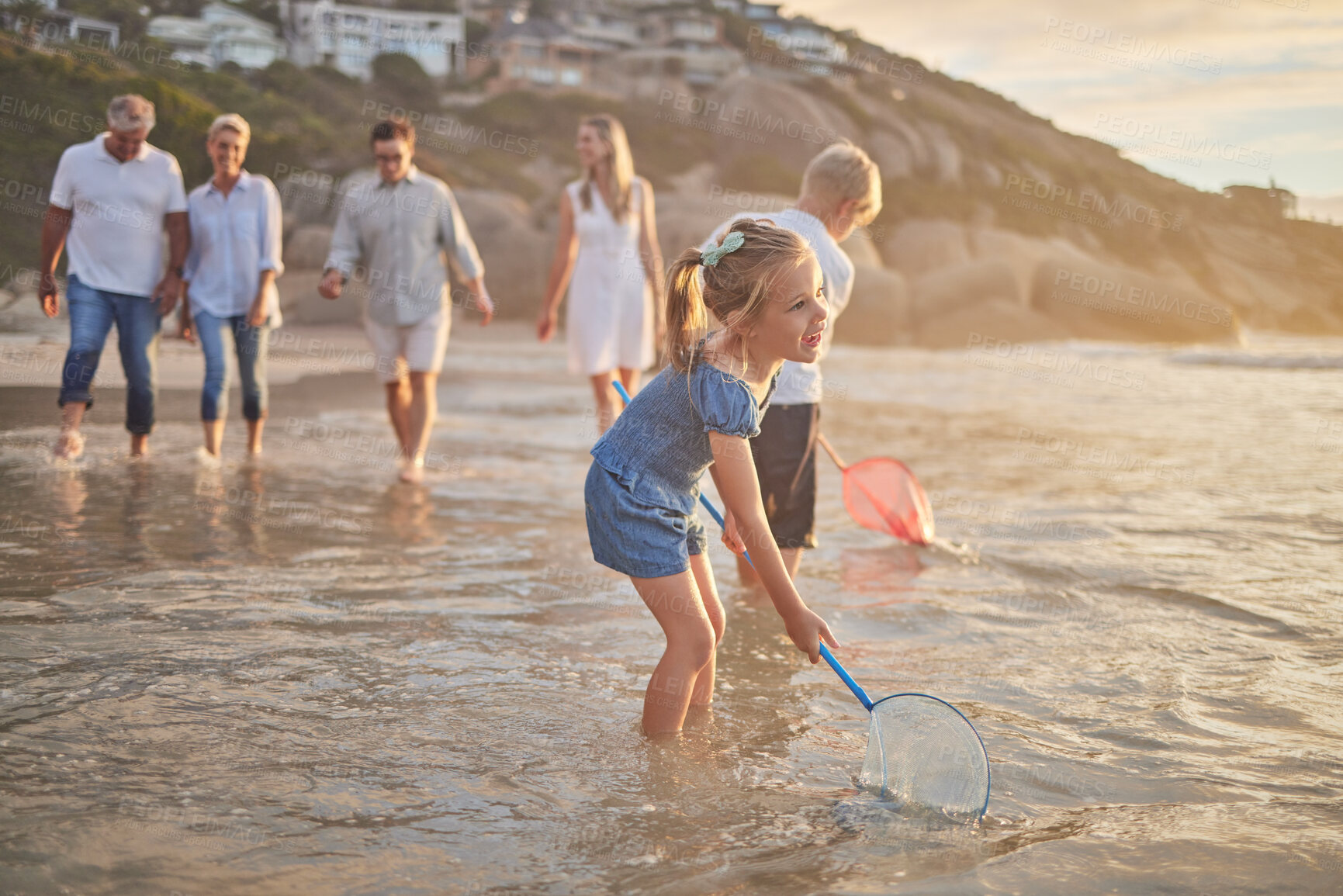 Buy stock photo Family, beach and fish net fun with parents and kids together with grandparents outdoor. Sunset, travel and love of generations with smile, happy youth and support on holiday by the sea in Florida