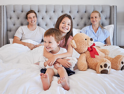 Buy stock photo Portrait, children and smile with embrace in bedroom for love, bonding and siblings support of childhood memory. Happy, kids and parents for hug, teddy bear and relax together in morning at house