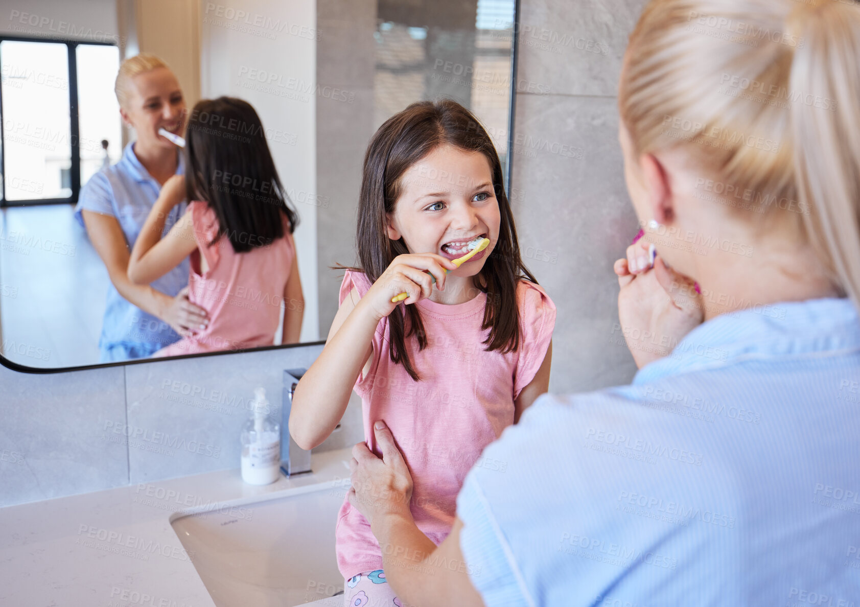 Buy stock photo Mother, daughter and brushing teeth in bathroom for teaching, dental and personal hygiene in morning. Woman, family and cleaning mouth in house for learning, oral and breath with toothbrush and back