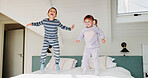 Children, jump and playing on bed in home for fun activity, entertainment and energy in morning with smile. Sibling love, people and playful with bonding, excited and freedom in bedroom on weekend