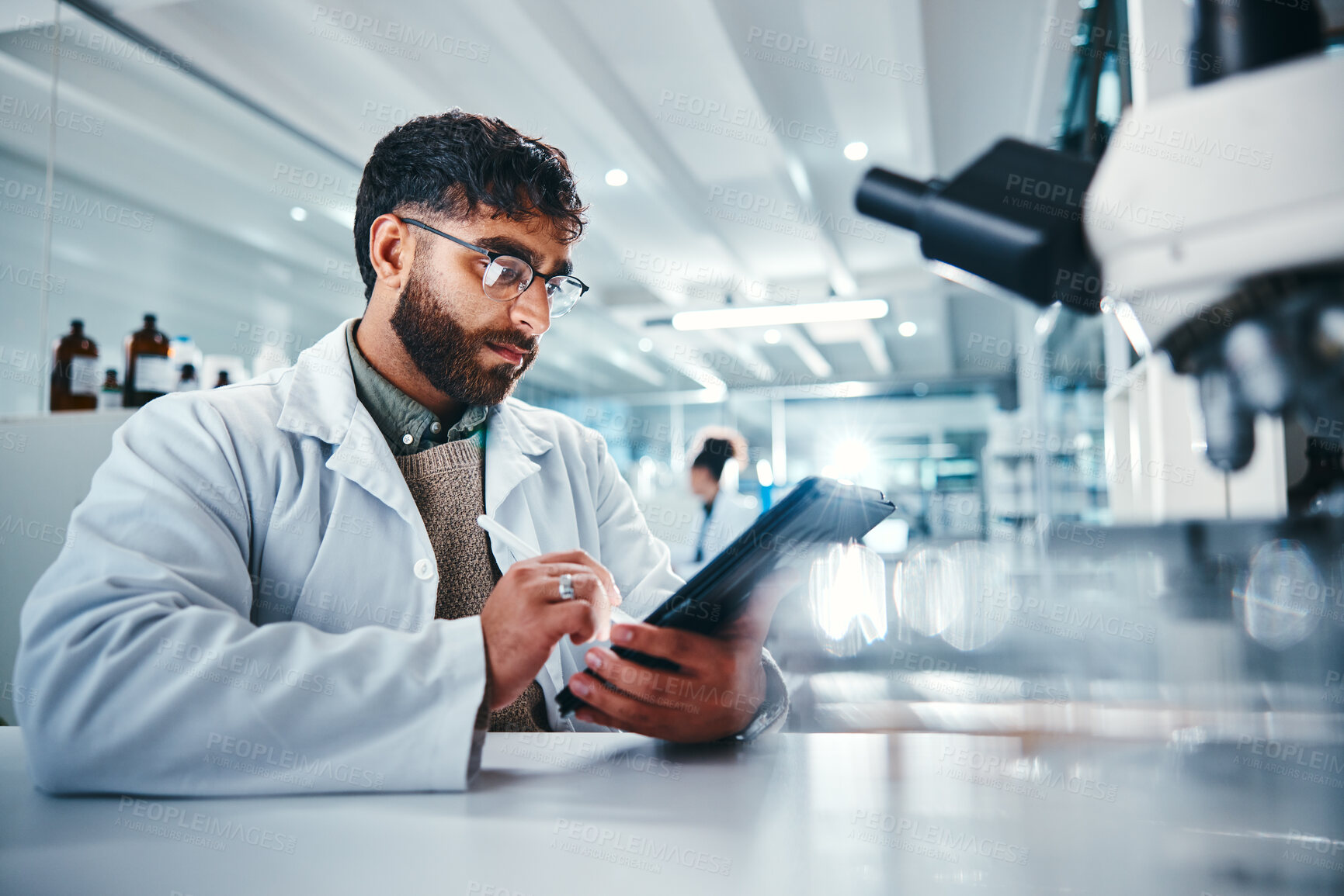 Buy stock photo Man, scientist and writing on tablet in lab for microscope research, medical data and science information. Person, researcher and digital for study feedback, vaccine solution and biotechnology cure