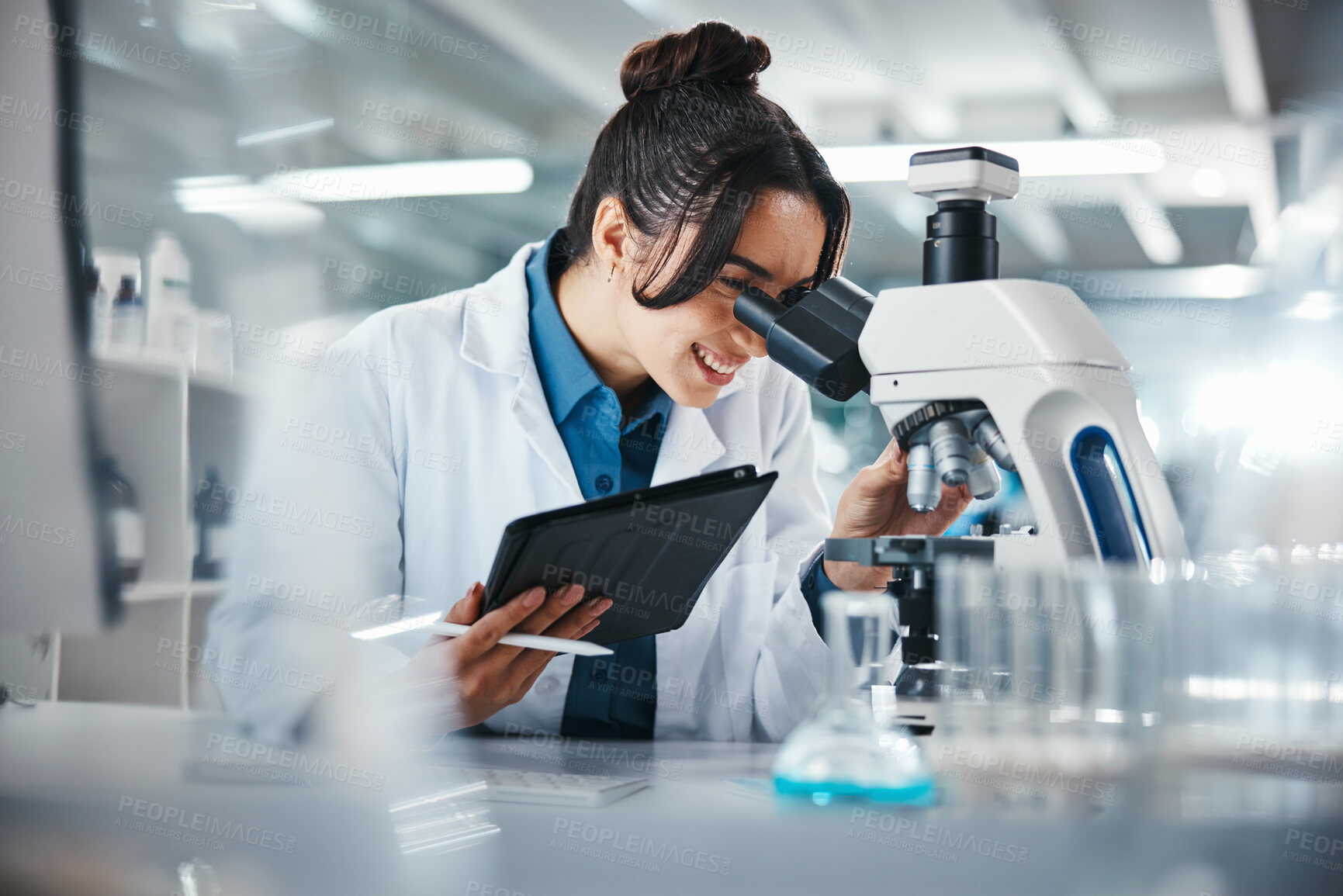 Buy stock photo Scientist, woman and microscope with tablet in lab for experiment research, medical data and science information. Smile, researcher and digital for biotechnology study, feedback and vaccine solution