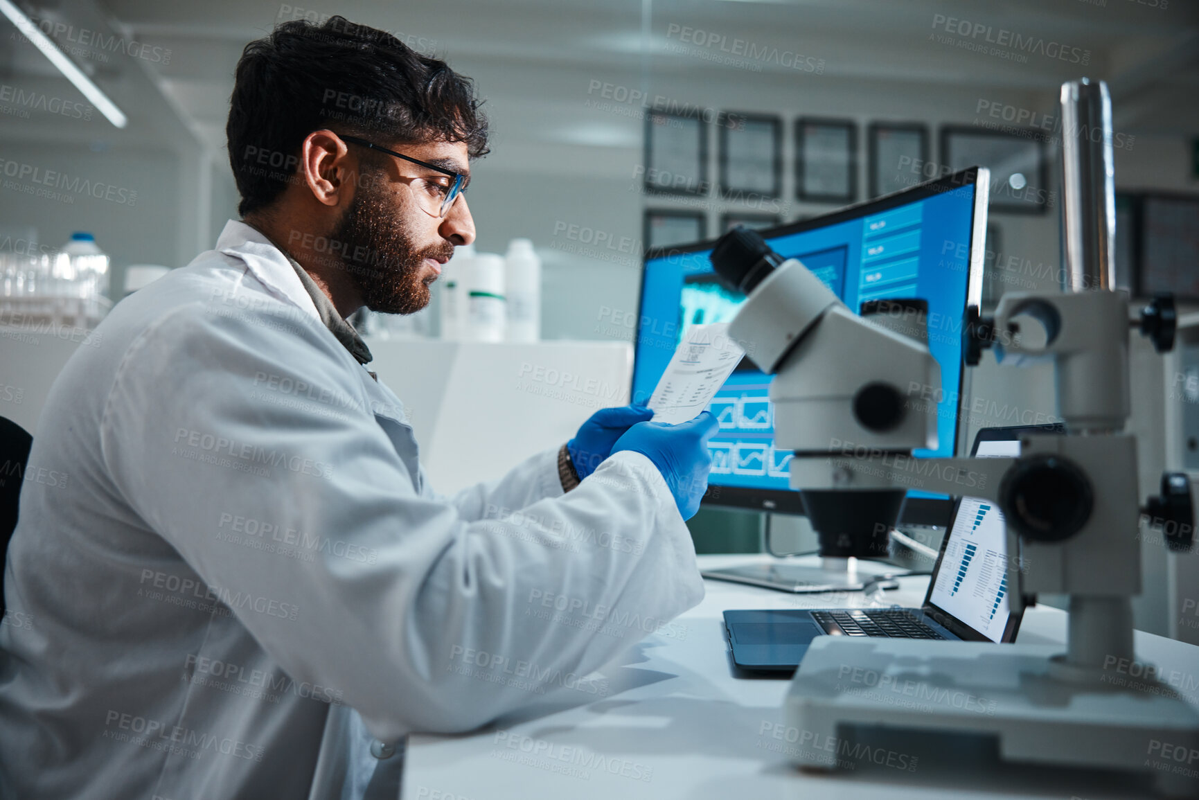 Buy stock photo Computer screen, paper and science with man in laboratory for development, innovation or research. Microscope, results and study with scientist reading at work on medical breakthrough or discovery