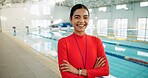 Crossed arms, woman and portrait of swimming coach at indoor pool for lesson, workout or training. Happy, confident and female lifeguard with pride for competition practice at aquatic center.