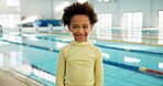 Portrait, boy and happy with confidence at swimming center for training, workout and practice for child development. Male person, kid and smile for sports challenge, tournament and fitness program